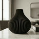 Black textured vase on a marble surface with a blurred background