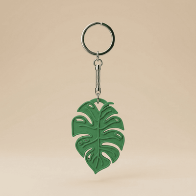 Green leaf-shaped keychain on a beige background