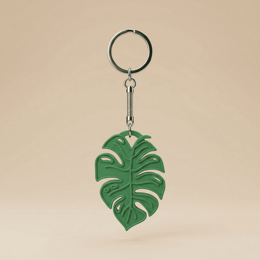 Green leaf-shaped keychain on a beige background