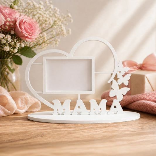 Decorative item with 'MAMA' on a heart-shaped stand, surrounded by flowers and soft lighting.