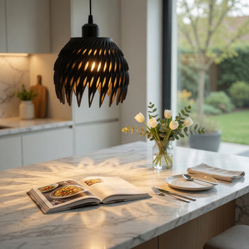 Modern kitchen with marble island, open cookbook, and decorative flowers.